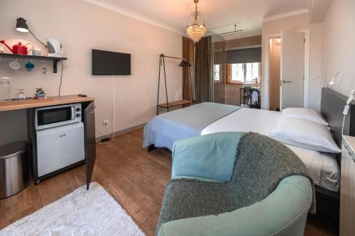 a hotel room with a bed and a couch at Galo Preto - Sintra Guesthouse in Sintra