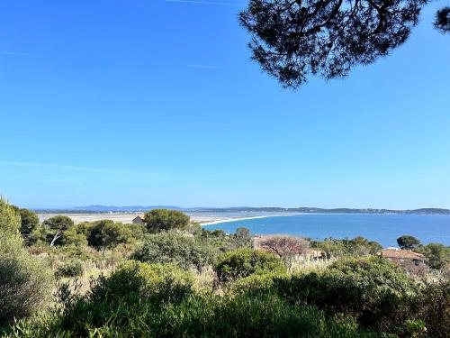 a view of the ocean from a hill with trees at Appartement accès direct mer in Hyères