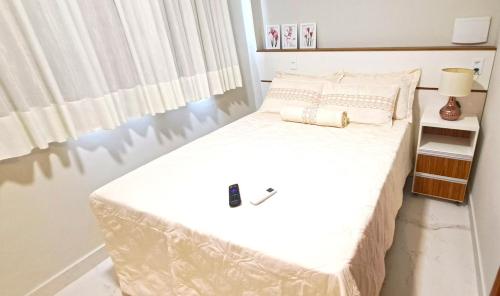 a bedroom with a large bed with white sheets at Flat da Eliete e Admilson 2 in Porto Seguro