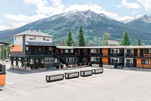 un grand bâtiment avec une montagne en arrière-plan dans l'établissement Mount Robson Inn, à Jasper