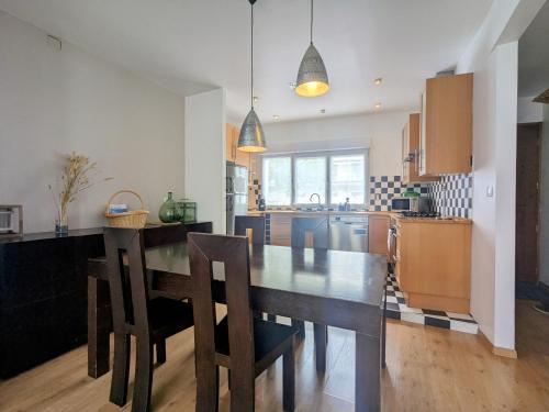 une cuisine avec une table et des chaises dans une cuisine dans l'établissement Spacieuse maison avec jardin, proche de Paris, à Houilles