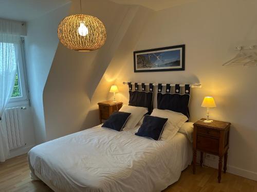 1 dormitorio con 1 cama blanca grande y 2 mesitas de noche en Chambres d'hôtes du Theven en Plougoulm