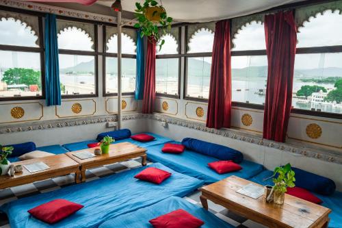 a room with blue tables and red pillows at Dreamyard Udaipur in Udaipur