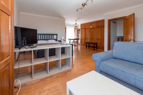 a living room with a blue couch and a tv at Galo Preto - Sintra Guesthouse in Sintra