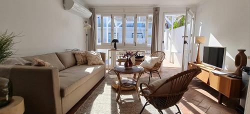 a living room with a couch and a table and chairs at Lavadeira's House in Olhão