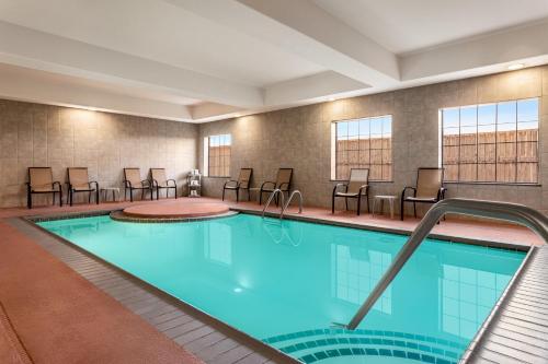 una piscina en una habitación de hotel con sillas en Baymont by Wyndham Wichita Falls, en Wichita Falls