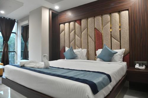 a bedroom with a large bed with a wooden headboard at City Square in Deoghar