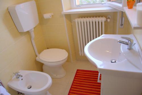Łazienka z białą toaletą i umywalką w obiekcie B&B Il Poggio w mieście Villagrande