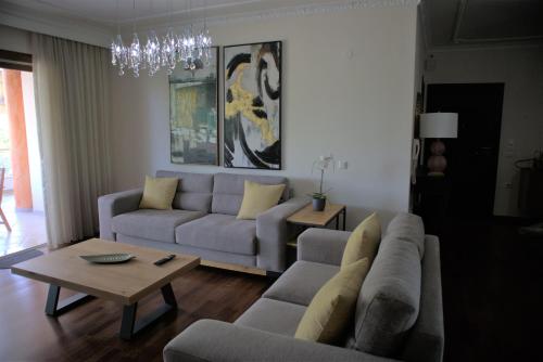 Kouros At The Park في أليكساندروبولي: غرفة معيشة مع أريكة وطاولة