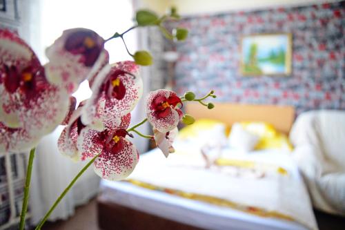 Habitación con cama con flores rosas y blancas en Jocó Panzió, en Nyíregyháza