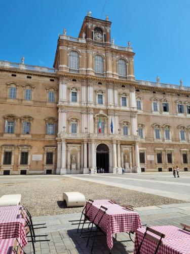 a large building with tables in front of it at Coco21 in Modena
