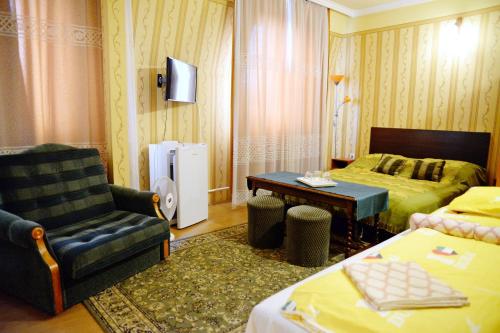 Zimmer mit einem Bett, einem Sofa und einem Stuhl in der Unterkunft Jocó Panzió in Nyíregyháza