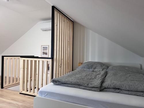 1 dormitorio con 1 cama y escalera en Best Apartman Lelle, en Balatonlelle