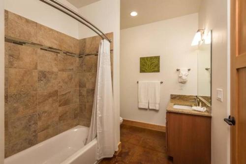 a bathroom with a tub and a shower and a sink at 57 Robber's Roost in Moab