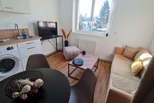 ein Wohnzimmer mit Sofa und Tisch in der Unterkunft Le Jaures 4 - T2 - 1er Etage in Hennebont