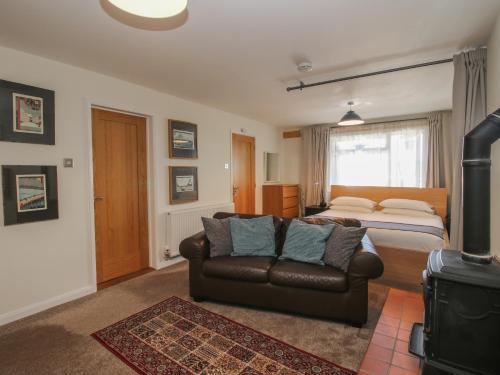 ein Schlafzimmer mit einem Bett und einem Sofa in einem Zimmer in der Unterkunft Plum Hill Studio in Oswestry