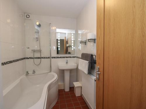 a white bathroom with a tub and a sink at Plum Hill Studio in Oswestry