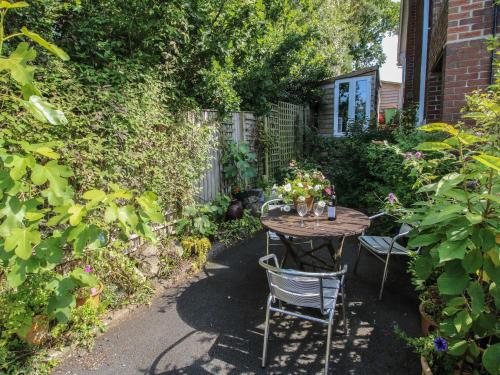a table in a garden with flowers on it at Plum Hill Studio in Oswestry