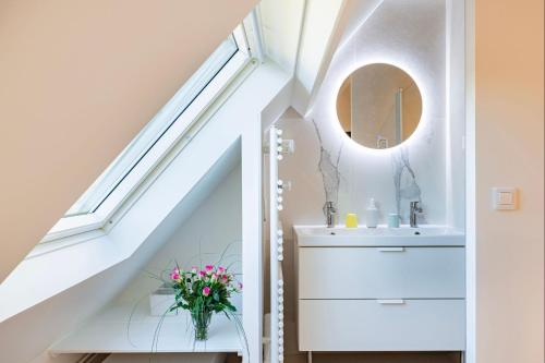 W łazience znajduje się umywalka i lustro. w obiekcie Bagatelle avec Jardin et Piscine Chauffée w mieście Biéville-en-Auge