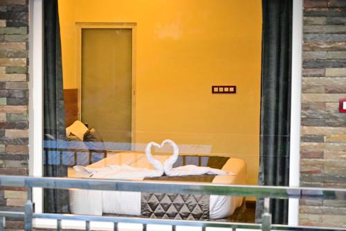 a store window with a white swan on a bed at Lasinara inn in Yercaud