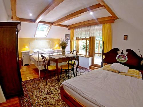 1 dormitorio con 1 cama y 1 mesa con sillas en Chalupa Branžež Komárovský rybník, en Branžež