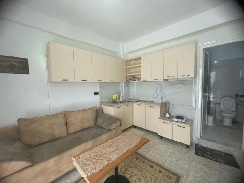 a living room with a couch and a kitchen at Flat in Tirana