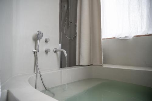 a bathroom with a shower and a bath tub with a shower at Torre Subrosa, vasca in camera cromoterapia in Viterbo