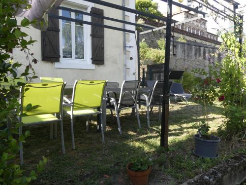 una mesa y sillas en el patio trasero de una casa en la maison du lac, en Aubin