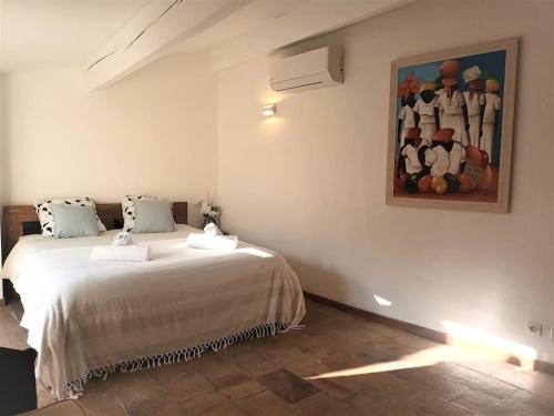 une chambre avec un lit avec un tableau sur le mur dans l'établissement Grand duplex lumineux-hyper centre, à Arles