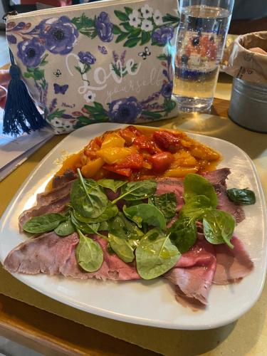 a plate of food with meat and greens on a table at Albergo Guido Reni in Turin