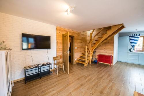 a living room with a staircase and a flat screen tv at Kolorowe Karkonosze in Przesieka