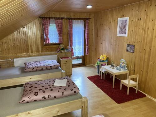 a bedroom with two beds and a table and a desk at VILLA MARTINI in Lazy pod Makytou