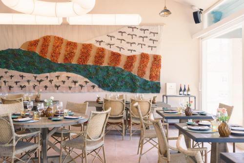 a dining room with tables and chairs and a large mural at Valverde Santar Hotel & SPA - Relais & Châteaux in Santar