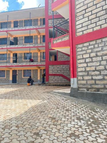 a person sitting in front of a building at Zoe Homes Oak Villa Apartment 1 and 2 Bedroom 201 in Kericho