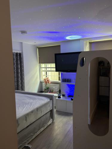 a bedroom with a bed and a tv on the wall at Beautiful double room in a central location next to various tube stations with breakfast and yoga options available on site in London