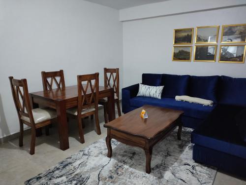 a living room with a blue couch and a table at Zoe Homes Oak Villa Apartment 1 and 2 Bedroom 201 in Kericho