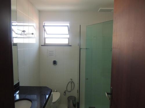 a bathroom with a shower and a sink and a toilet at Loft Com Vista Para O Mar in Arraial do Cabo