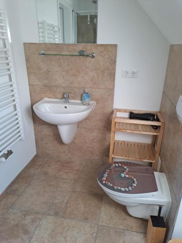 a bathroom with a sink and a toilet and a sink at Ein Stück Glück in Prerow