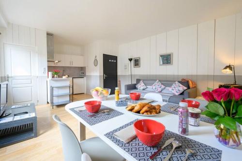 eine Küche und ein Wohnzimmer mit einem Tisch mit Essen drauf in der Unterkunft Au cœur de St Martin : Les Grenettes in Saint-Martin-de-Ré
