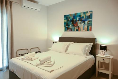 een slaapkamer met een bed met twee handdoeken erop bij Larisa Hospitality II - St Nicholas apartment - with Free Parking in Larisa
