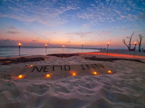 a sign that says me no limits in the sand on a beach at Nemo Inn in Omadhoo