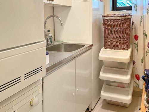 cocina blanca con fregadero y encimera en Holiday home KIL II en Kil