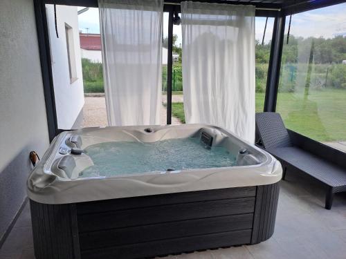 una grande vasca da bagno in una stanza con finestra di kuća za odmor Domus Alba a Branjin Vrh