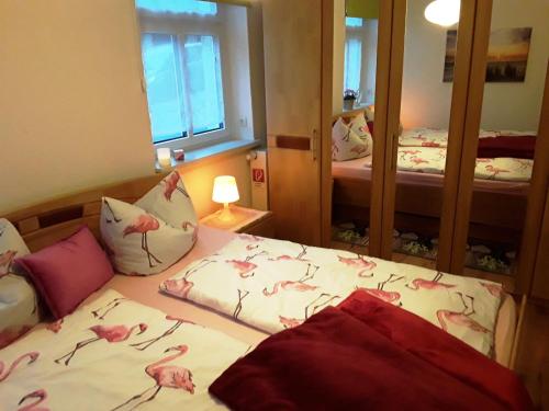 ein Schlafzimmer mit einem Bett mit rosa Flamingos darauf in der Unterkunft FeWo Ruhe-Insel Musikwinkel in Markneukirchen
