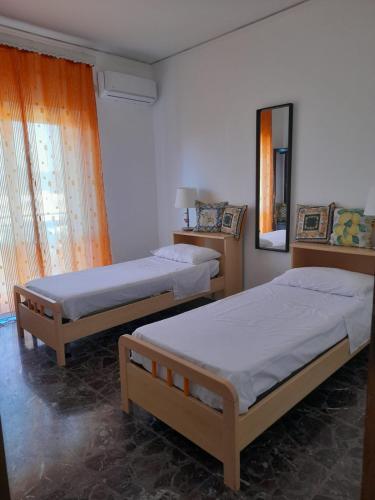 a bedroom with two beds and a mirror at A Casa Di Alex in Catania