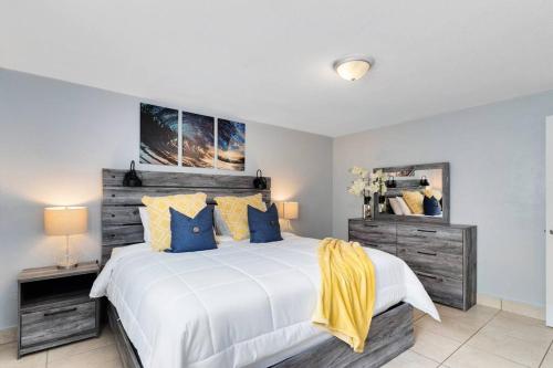 a bedroom with a large bed with blue and yellow pillows at Ocean 7 - Palmside in Indian Harbour Beach