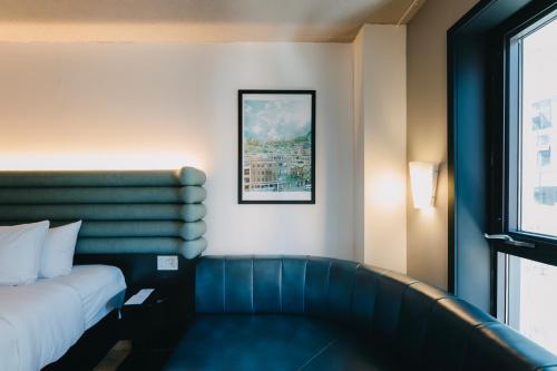 a hotel room with a bed and a couch at Le Dauphin Montréal Centre-Ville in Montréal