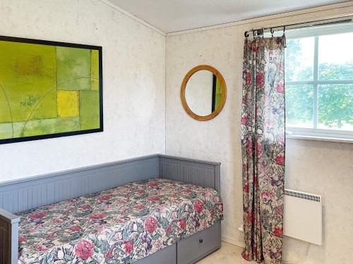 a bedroom with a bed and a mirror and a window at Holiday home KIL III in Kil