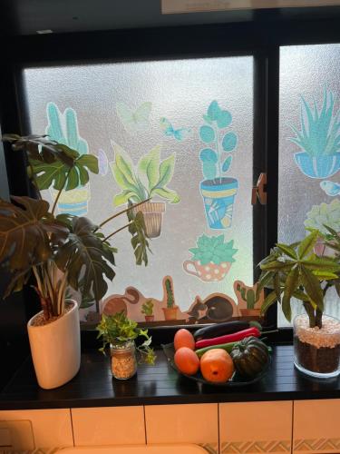 a window with plants and a plate of fruit and vegetables at 舟荘 in Osaka