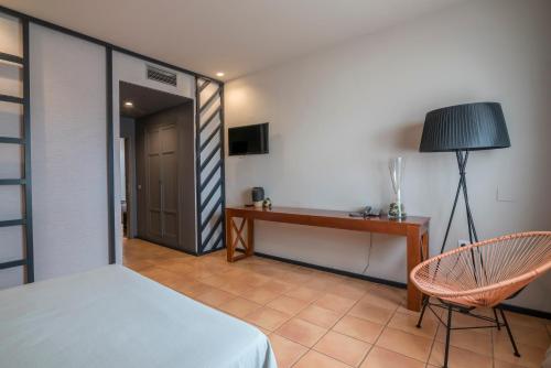 a bedroom with a bed and a desk and a chair at Hotel El Coto De Quevedo in Torre de Juan Abad